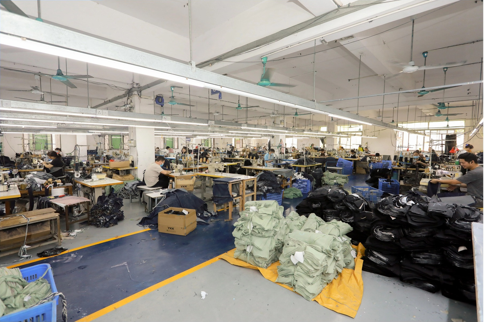 Actual garment production workshop with sewing lines and workers